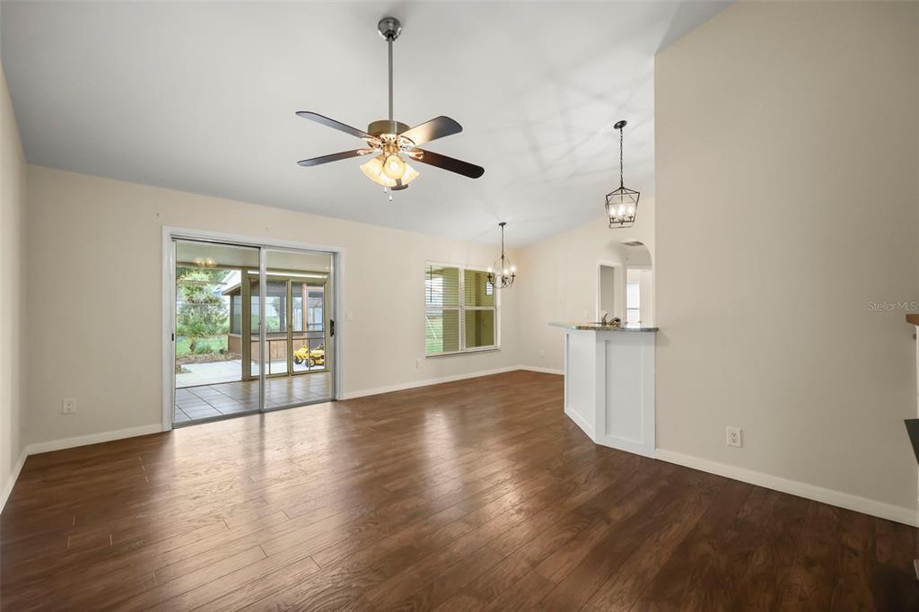 A dining area with wood-look flooring, a ceiling fan, and a sliding glass door — 14513 POINTE EAST TRAIL, CLERMONT, FL
