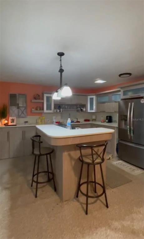A kitchen features a curved breakfast bar with two stools, light cabinetry, and peach-colored walls — 507 VICENTA ARROYO, MANATI, PR