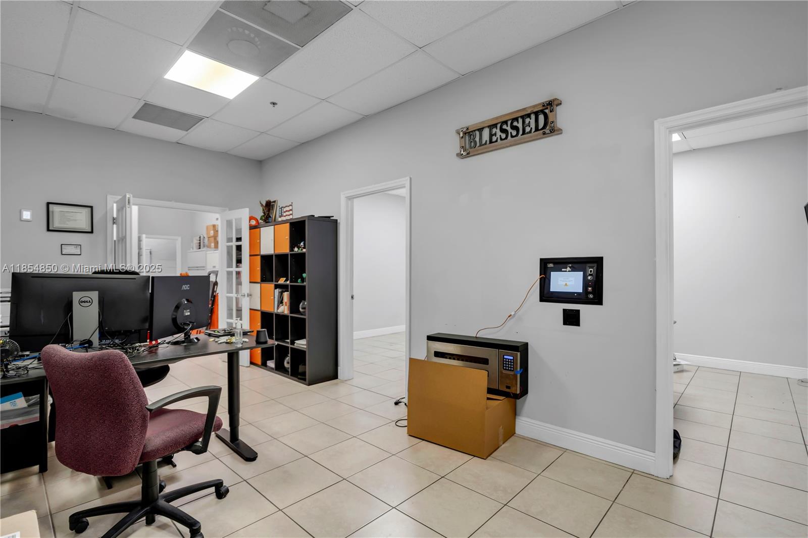 A bright hallway features tiled floors, a drop ceiling, and glass walls overlooking a parking lot — 4310 SW 73rd Ave # 438890, Miami FL 33155, MIAMI, FL