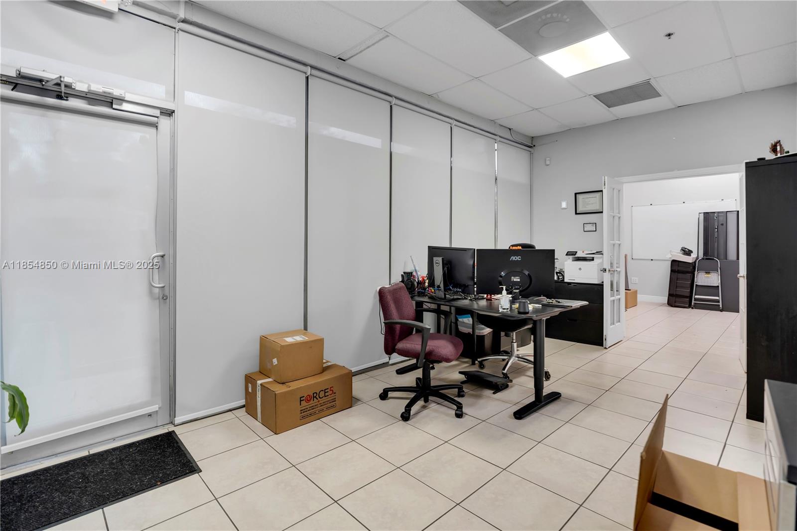 An empty commercial space features light-colored tile flooring, a drop ceiling, and large glass windows — 4310 SW 73rd Ave # 438890, Miami FL 33155, MIAMI, FL
