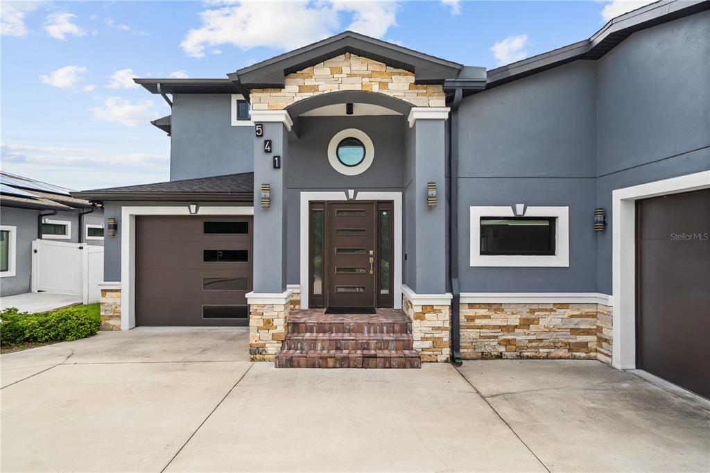 A two-story house exterior features a gray facade, stone accents, and a dark brown front door — 541 W LAKE BRANTLEY ROAD, ALTAMONTE SPRINGS, FL