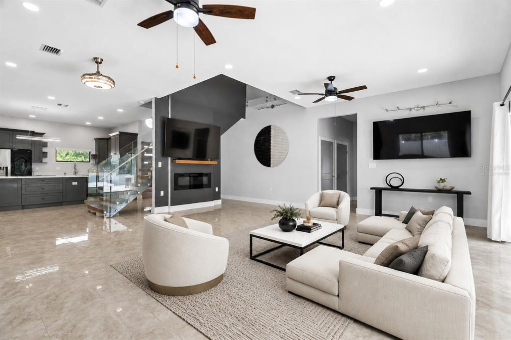 A modern open-concept living room features light tile floors, a sectional sofa, and a fireplace — 541 W LAKE BRANTLEY ROAD, ALTAMONTE SPRINGS, FL