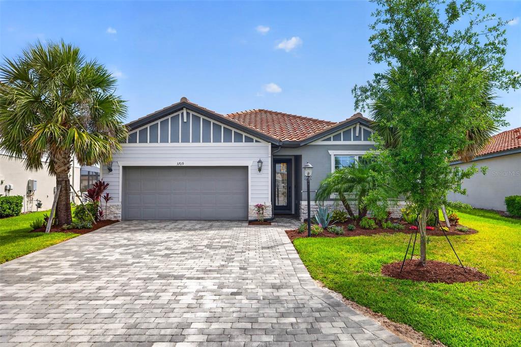 A single-story house with a gray garage, white siding, and a paved driveway — 3709 SAVANNA PALMS COURT, BRADENTON, FL