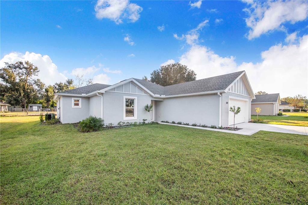 A light gray single-story house with a white garage and a large front lawn — 500 9TH STREET NE, FORT MEADE, FL