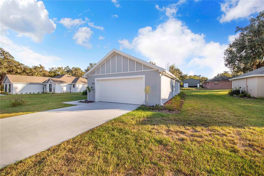 A view of the exterior of a light gray house with a two-car garage — 500 9TH STREET NE, FORT MEADE, FL