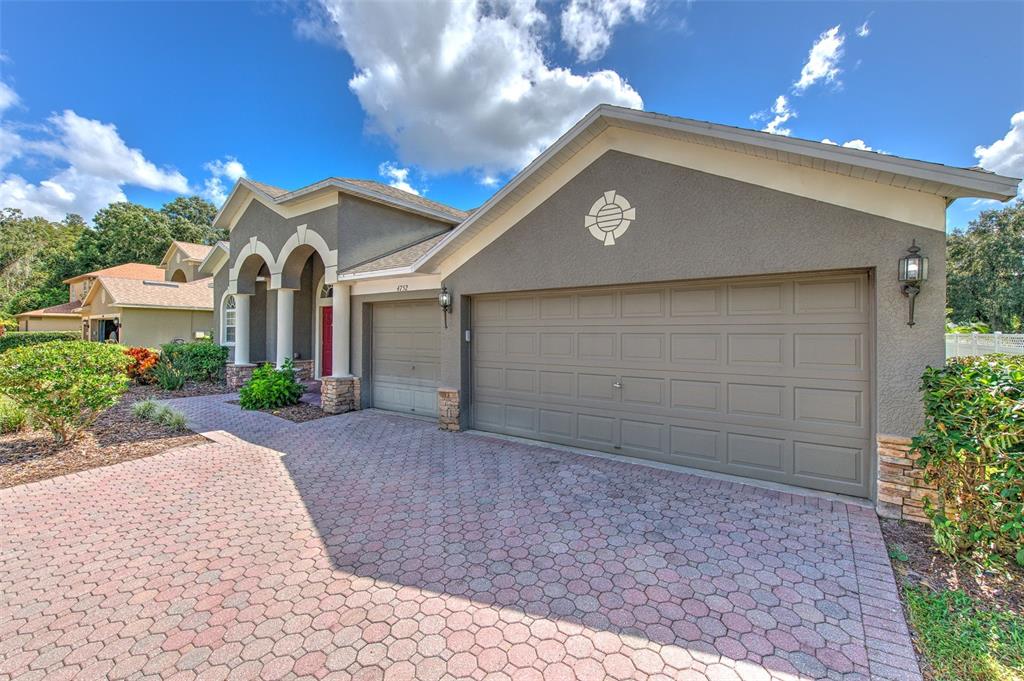 A kitchen with wood cabinets, stainless steel appliances, and a dark granite breakfast bar — 4752 PATAGONIA PLACE, LAND O LAKES, FL