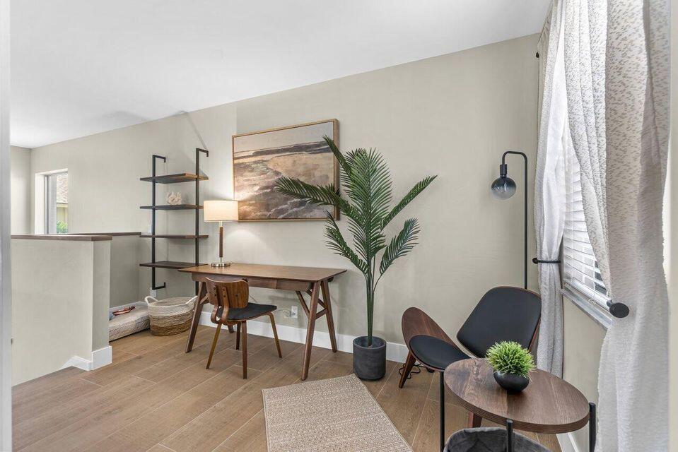 A home office features a wooden desk, a black chair, a bookshelf, and a plant — 17138 Waterbend Drive # 217, Jupiter FL 33477, JUPITER, FL