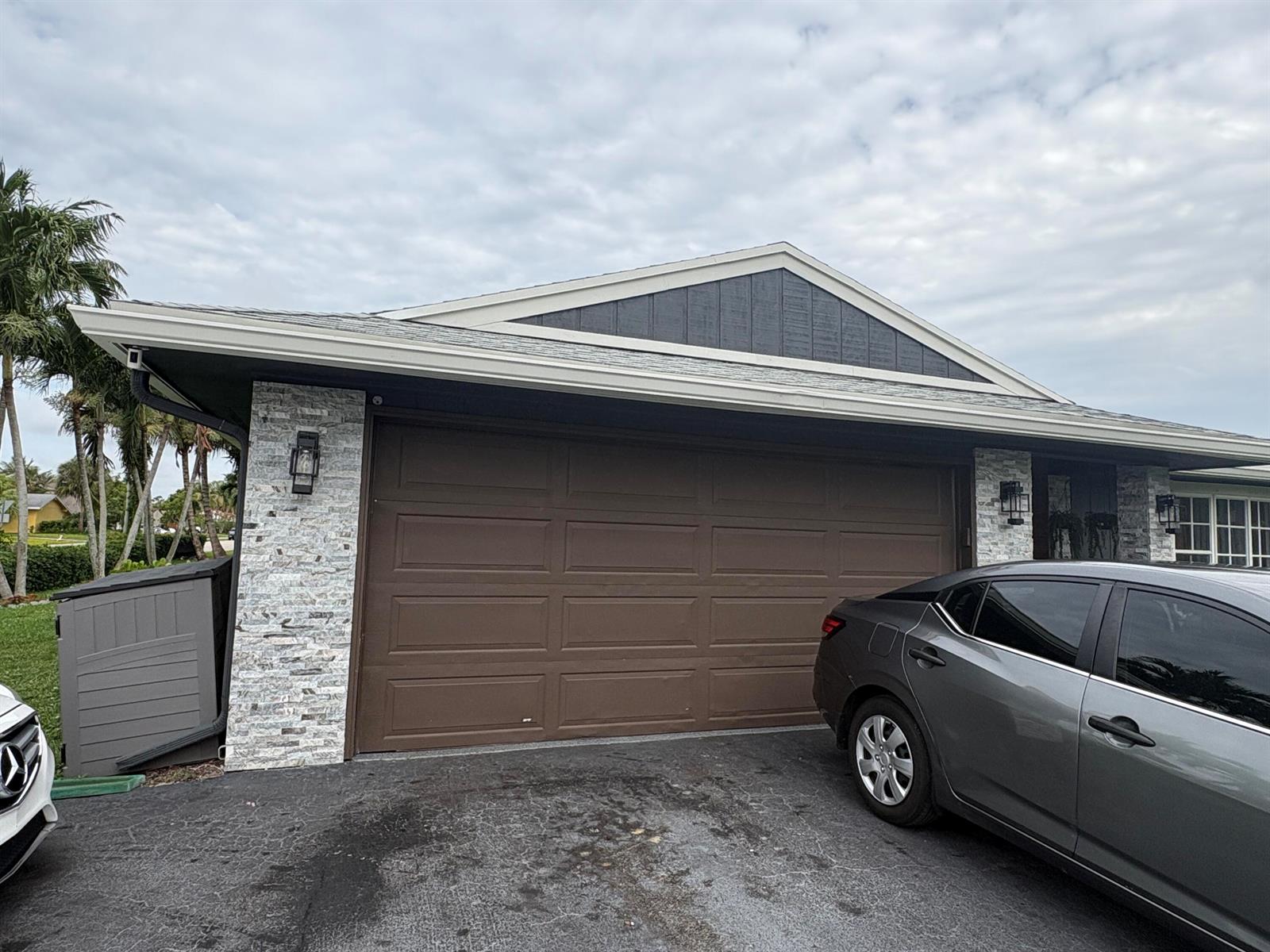 A gray car is parked in front of a house with a brown garage door — 3501 Boulevard Boulevard, Delray Beach FL 33445, DELRAY BEACH, FL