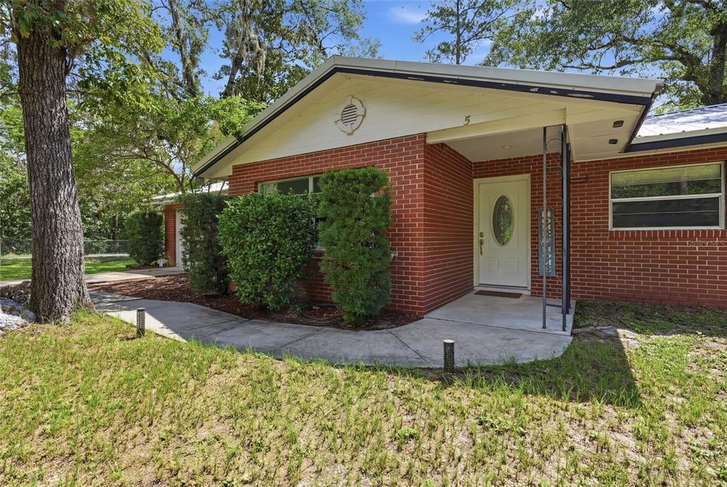 A single-story brick house with a white front door and a concrete walkway — 5 SW 41ST STREET, GAINESVILLE, FL