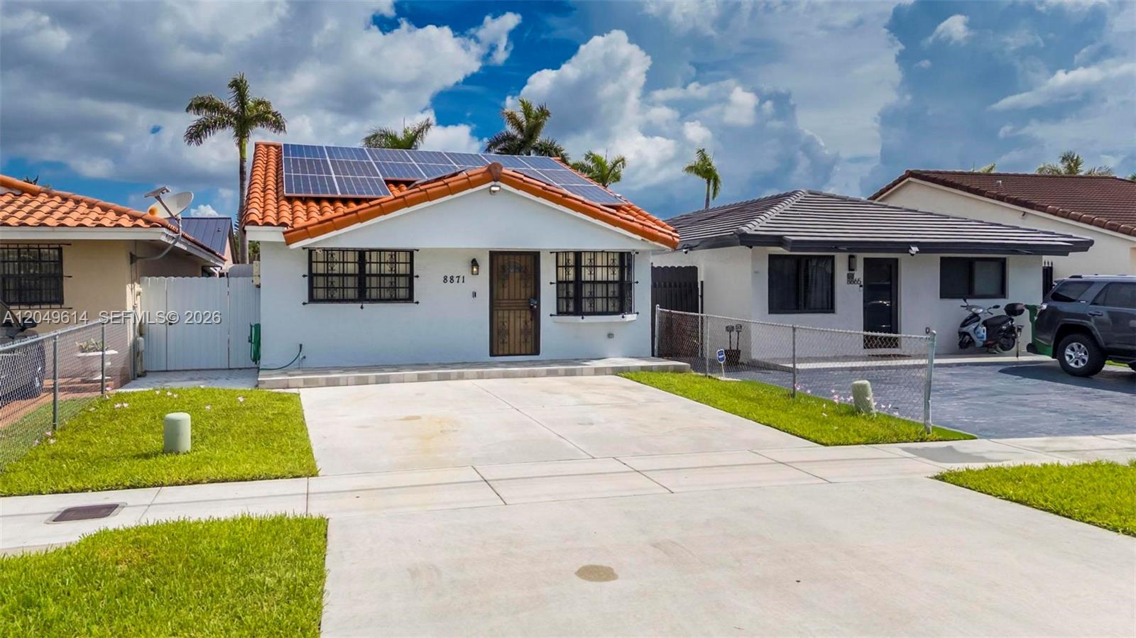 A single-story house with a tiled roof, solar panels, and a concrete driveway — 8871 NW 114th St, Hialeah Gardens FL 33018, HIALEAH GARDENS, FL