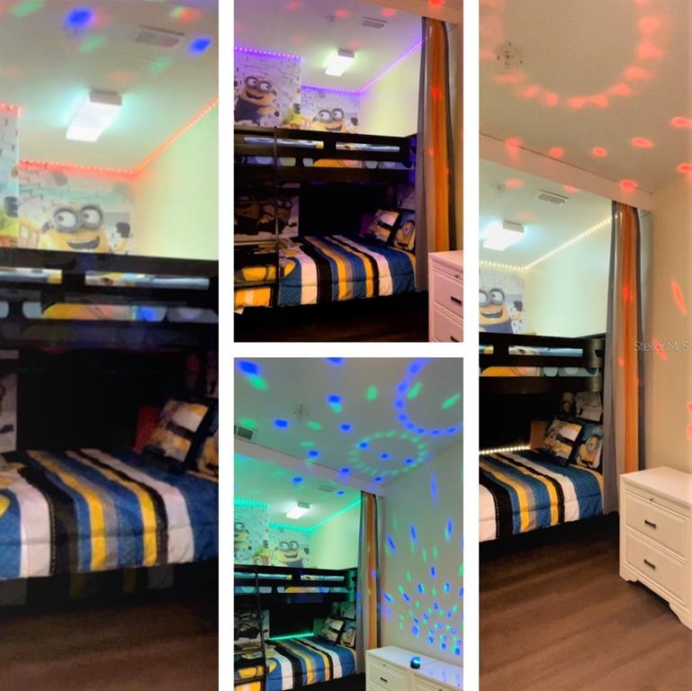 A bedroom features a dark wood bunk bed with Minion-themed bedding and colorful disco lighting — 7671 COMROW STREET UNIT 302, KISSIMMEE, FL