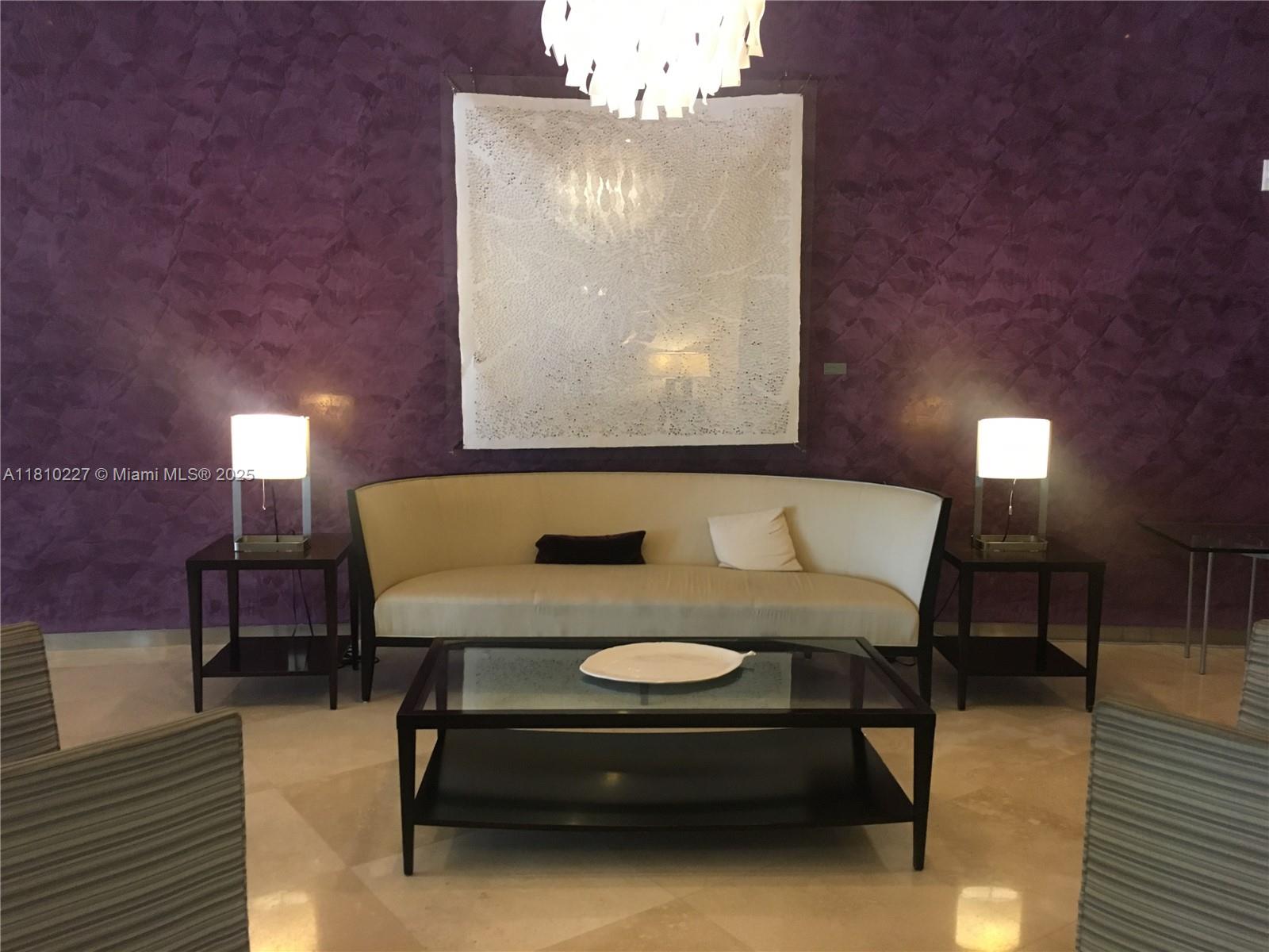 A living area features a cream sofa, glass coffee table, and lamps against a purple wall — 10275 Collins Ave # 628, Bal Harbour FL 33154, BAL HARBOUR, FL