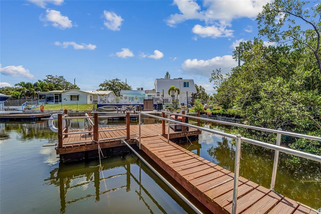 A kitchen features cream-colored cabinets, granite countertops, a subway tile backsplash, and stainless steel appliances — 8542 BETTY STREET, PORT RICHEY, FL