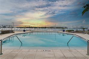 A swimming pool with metal handrails overlooks a bay at sunset — 800 West Ave # 523, Miami Beach FL 33139, MIAMI BEACH, FL