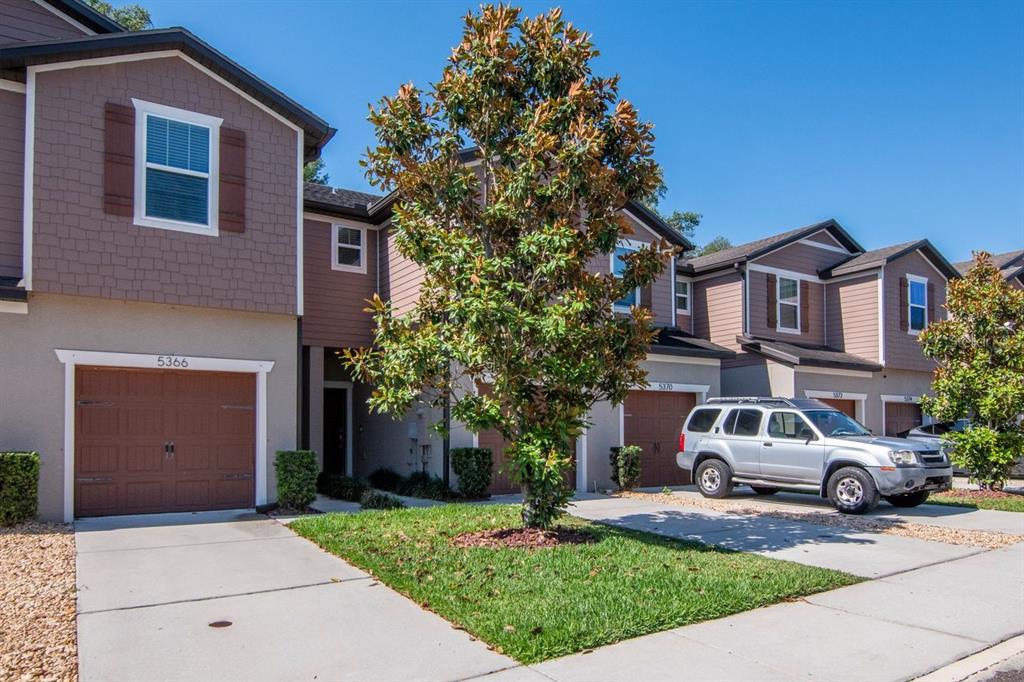 A kitchen with wood cabinets and a breakfast bar overlooks a dining area with chairs — 5368 SYLVESTER LOOP, TAMPA, FL