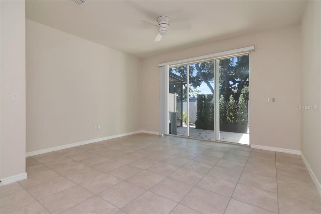 A living room features a sofa, round coffee table, armchair, and sliding glass doors to a patio — 5368 SYLVESTER LOOP, TAMPA, FL