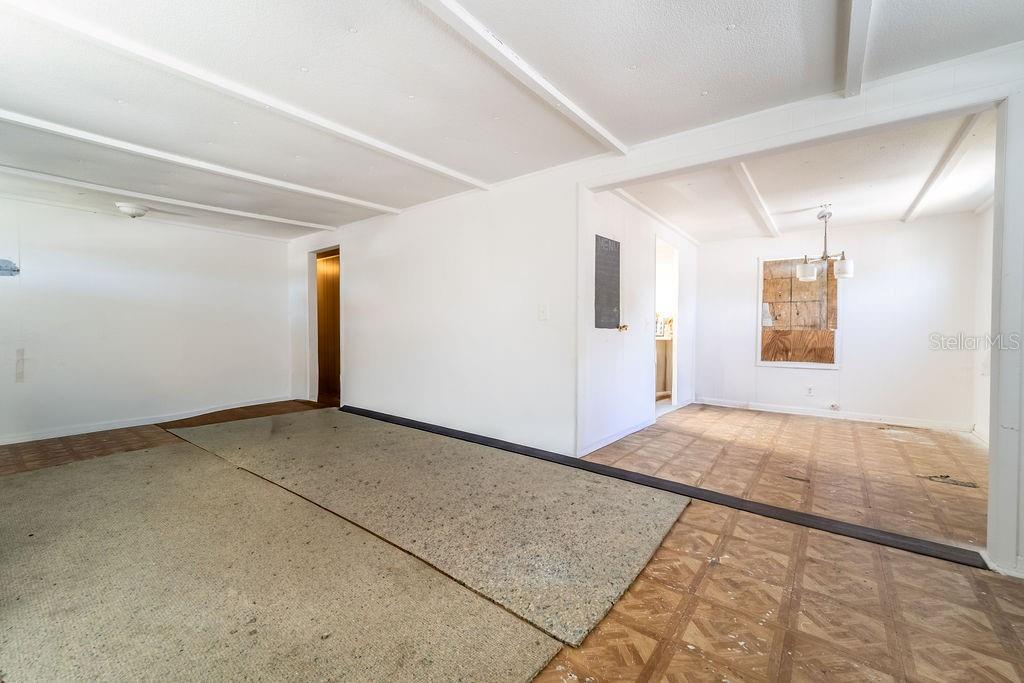 An interior view shows a living area with exposed subflooring and a separate dining space — 2900 STATE ROAD 11, DELAND, FL