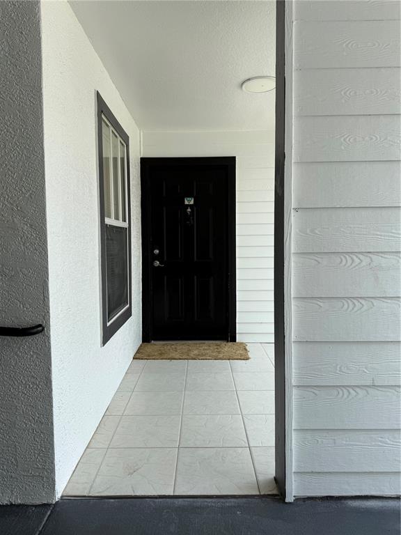 A covered entryway features a black front door, a window, and light-colored tiled flooring — 2208 ANTIGUA PLACE UNIT 914, KISSIMMEE, FL