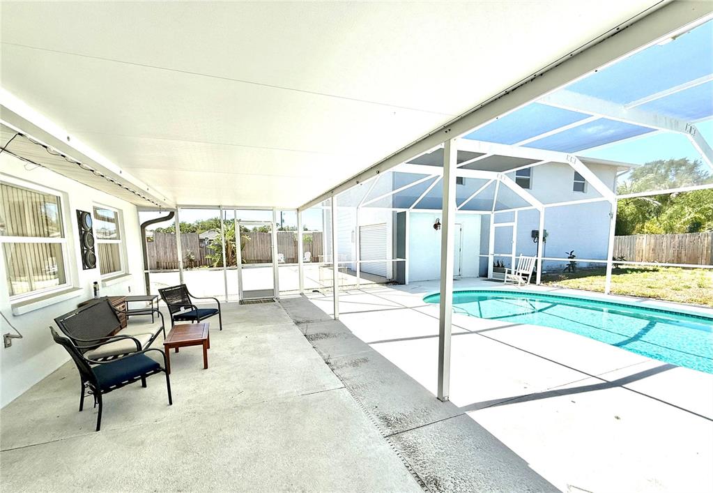 A covered patio with a screen enclosure overlooks a swimming pool and a backyard — 1505 MORGAN STREET, NOKOMIS, FL