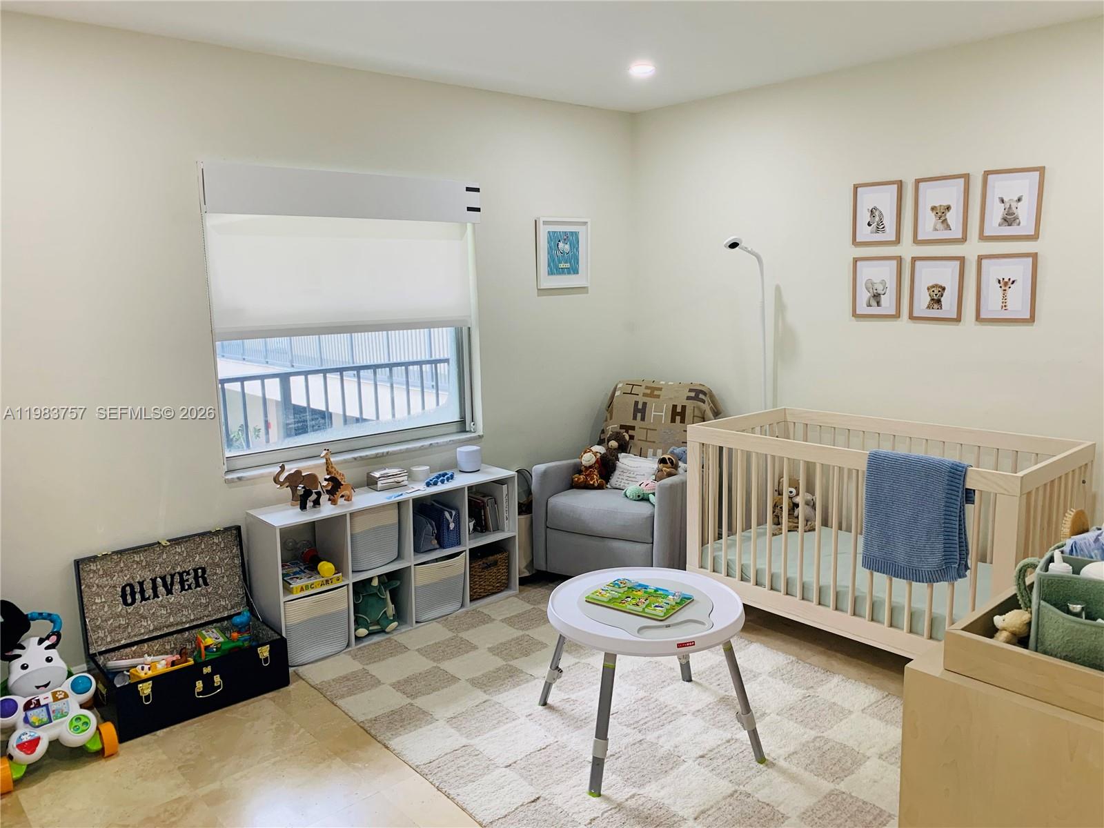 A nursery features a crib, a storage unit, a rocking chair, and a patterned rug — 6815 Edgewater Dr # 105, Coral Gables FL 33133, CORAL GABLES, FL