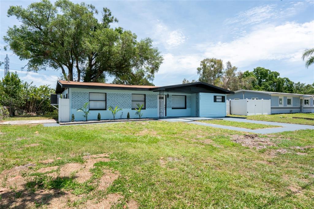 A light blue, single-story house with a dark roof and a large tree in front — 415 COUNTRY CLUB DRIVE, OLDSMAR, FL