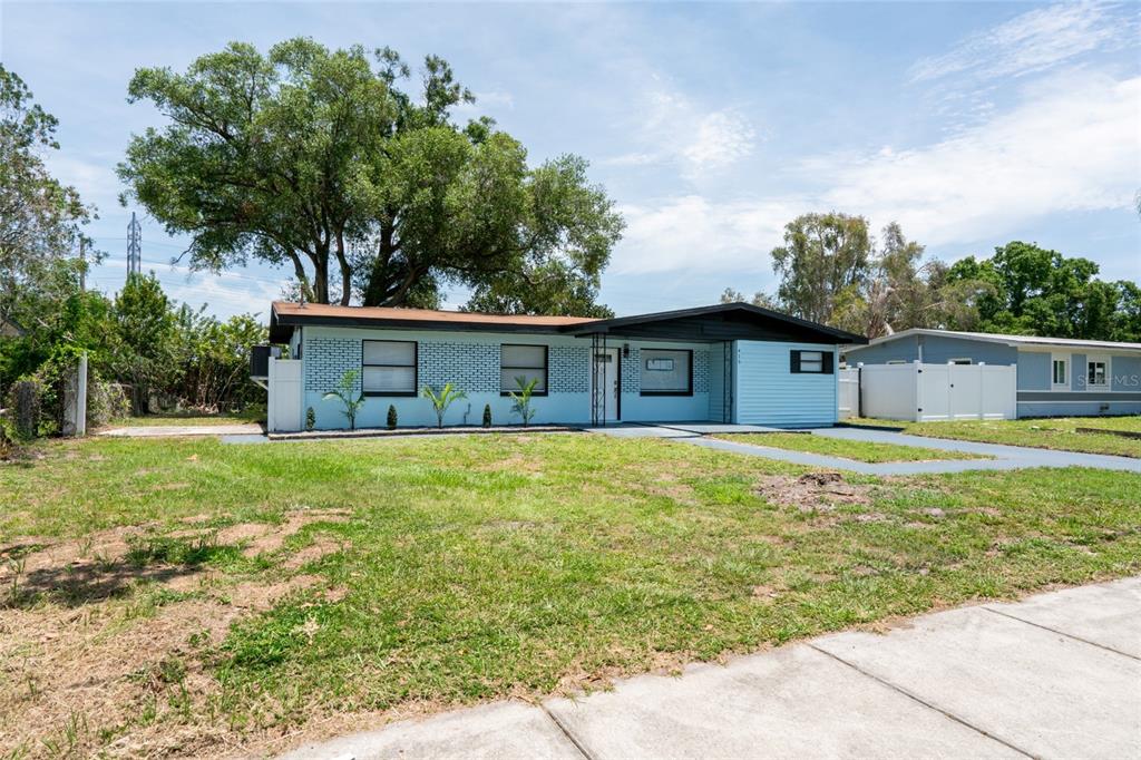 A light blue single-story house with a black roof and a large front yard — 415 COUNTRY CLUB DRIVE, OLDSMAR, FL