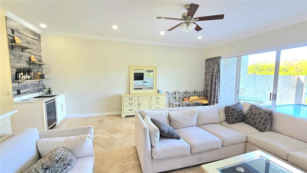 A living room features a wet bar, a large sectional sofa, and sliding glass doors — 1806 LAGO VISTA BOULEVARD, PALM HARBOR, FL