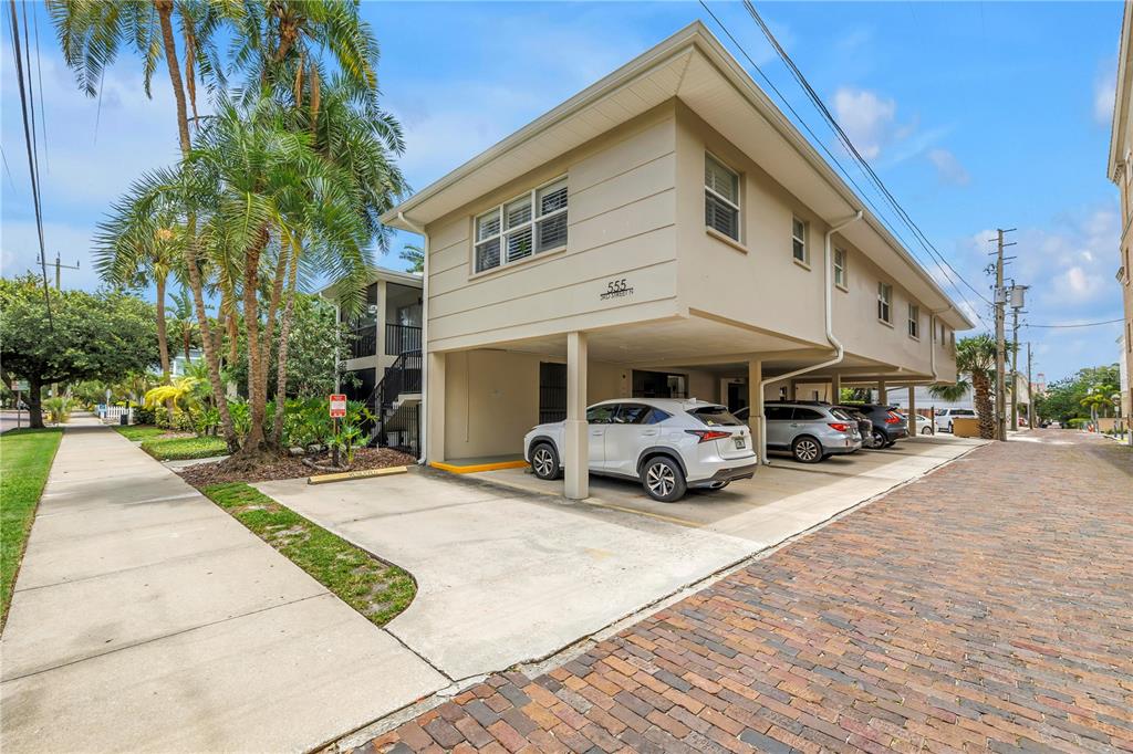 A two-story building with a covered ground-level parking area and a brick-paved street — 555 3RD STREET N UNIT 13, ST PETERSBURG, FL