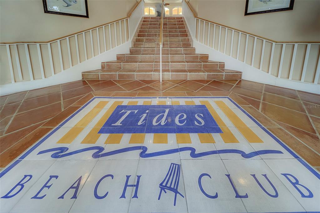 A tiled staircase leads up from a lobby floor featuring a Tides Beach Club logo — 16700 GULF BOULEVARD UNIT 423, NORTH REDINGTON BEACH, FL