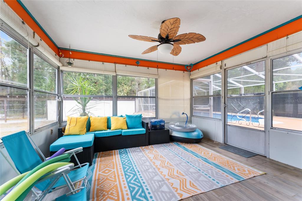 A sunroom features a wicker sectional, a patterned area rug, and a ceiling fan — 8345 SW 200TH COURT, DUNNELLON, FL