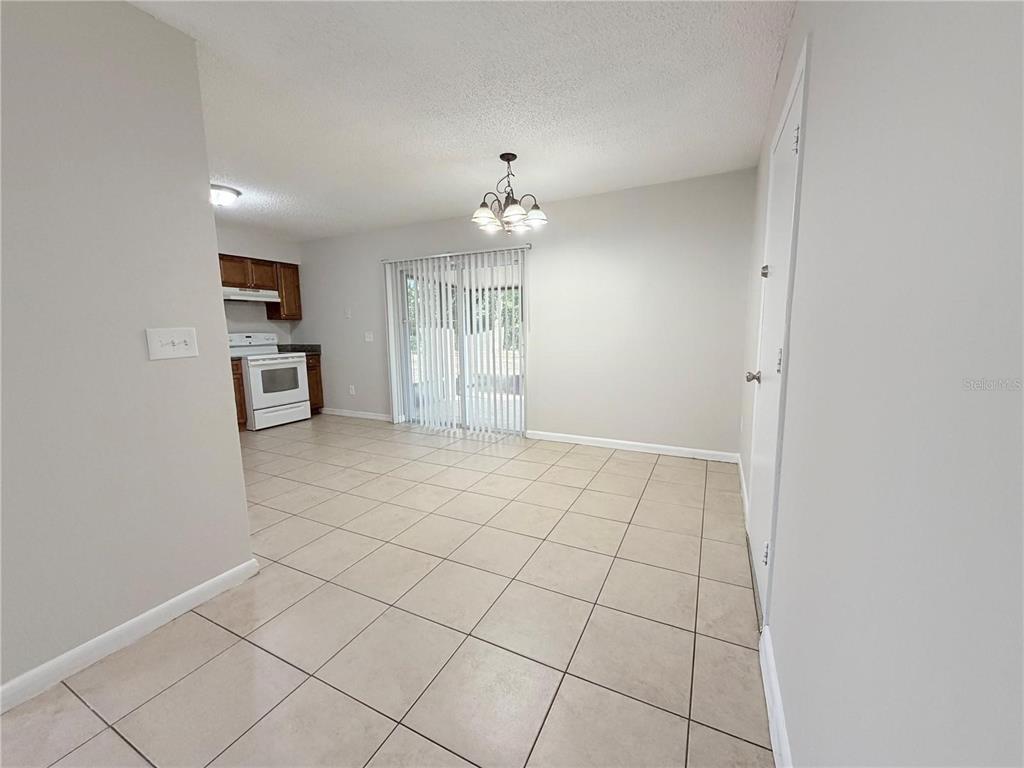 A dining area with tile flooring, a chandelier, and a sliding glass door to the outside — 330 DOGWOOD AVENUE, ORANGE CITY, FL
