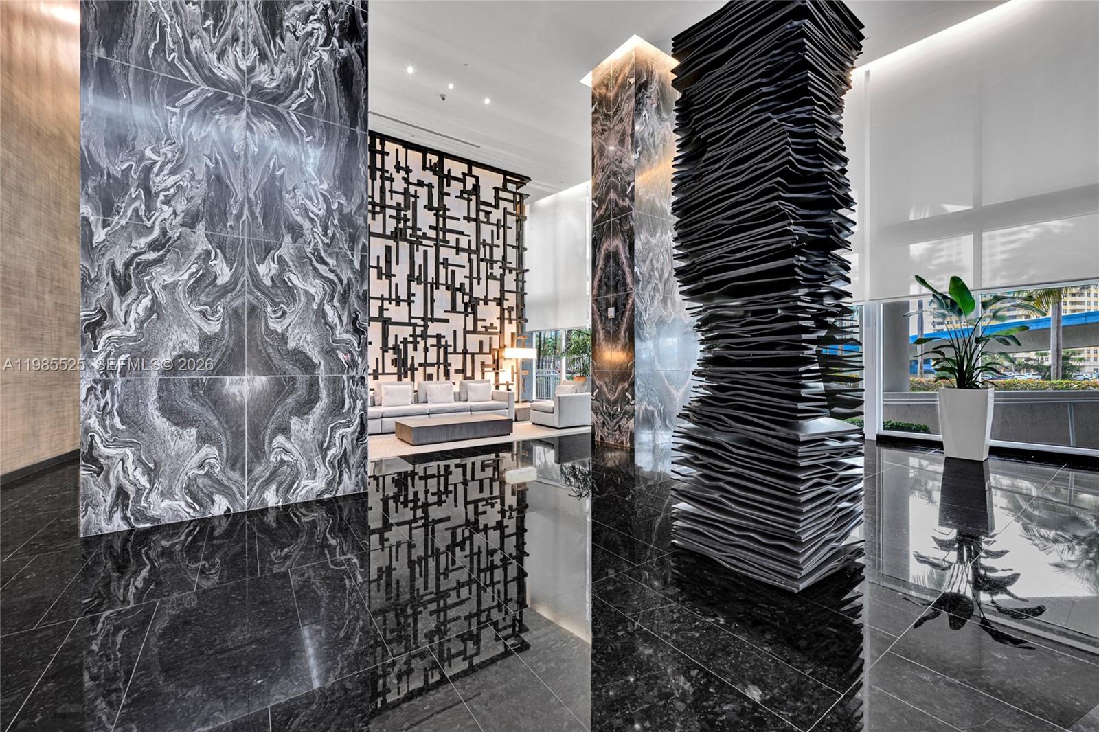 A modern lobby features black marble floors, a sculptural pillar, and a geometric room divider — 1800 S Ocean Drive # 3908, Hallandale Beach FL 33009, HALLANDALE BEACH, FL