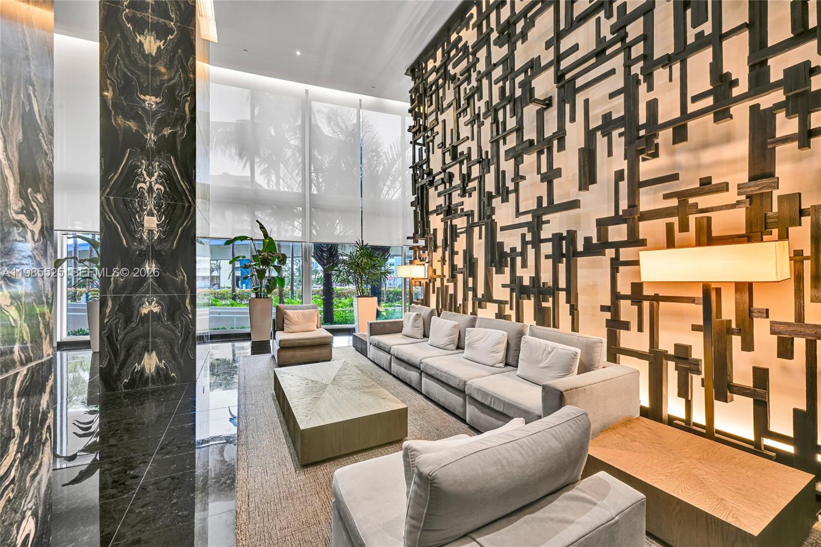 A modern lobby features a large geometric wall sculpture, plush gray seating, and marble accents — 1800 S Ocean Drive # 3908, Hallandale Beach FL 33009, HALLANDALE BEACH, FL