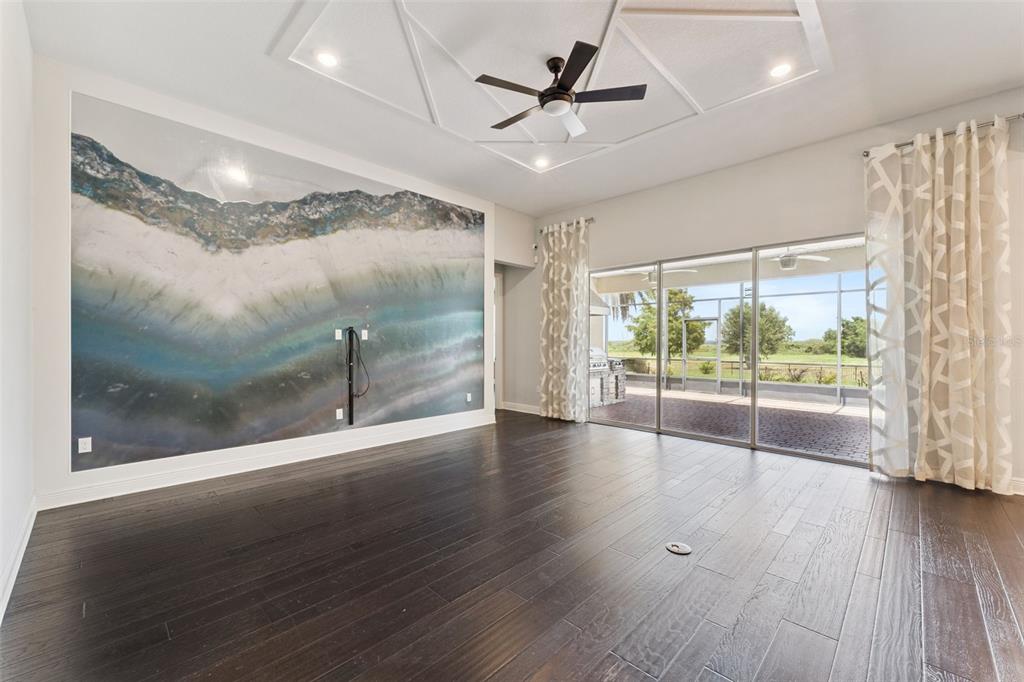 A living room features dark wood floors, a geometric ceiling design, and a large wall mural — 1511 GATEWAY LANE, KISSIMMEE, FL