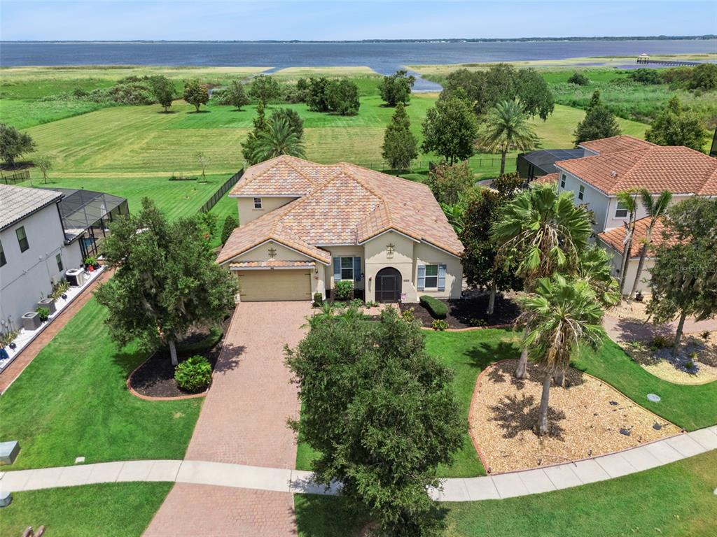 An aerial view shows a single-family home with a tiled roof and a paved driveway — 1511 GATEWAY LANE, KISSIMMEE, FL