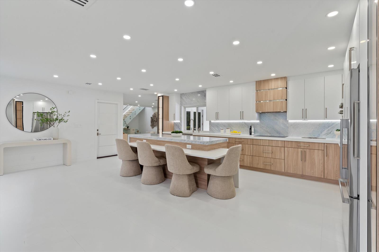 A modern kitchen features a central island with bar seating, white cabinetry, and wood accents — 440 NW 11th Avenue, Boca Raton FL 33486, BOCA RATON, FL