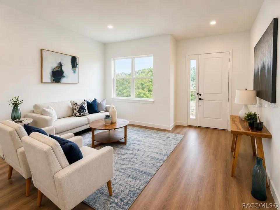 A living room features light wood-look flooring, a white sofa, two armchairs, and a rug — 9509 N OLD MILL WAY, DUNNELLON, FL