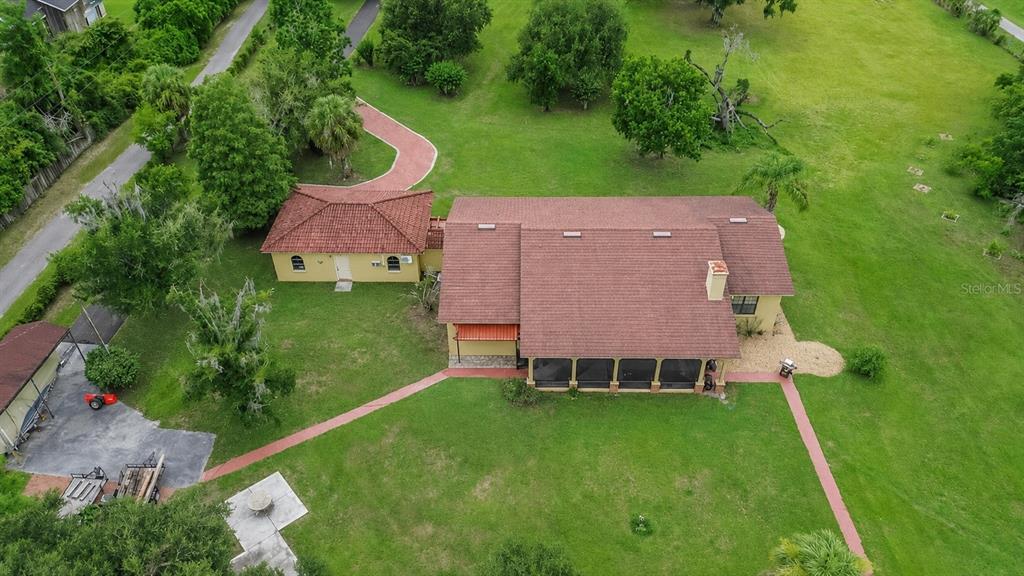 An aerial view shows a house with a brown roof, a detached garage, and walkways — 4020 N WILDER ROAD, PLANT CITY, FL