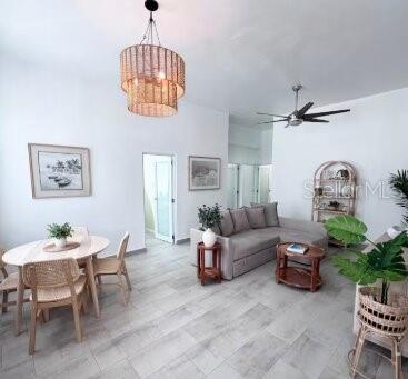 A bright living and dining area features light wood-look tile floors and a woven chandelier — 250 CALLE DEL PARQUE UNIT 1A, SAN JUAN, PR