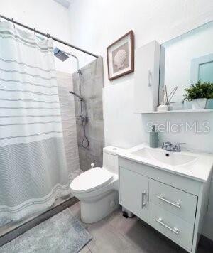 A bathroom featuring a walk-in shower, a white vanity, and a toilet — 250 CALLE DEL PARQUE UNIT 1A, SAN JUAN, PR