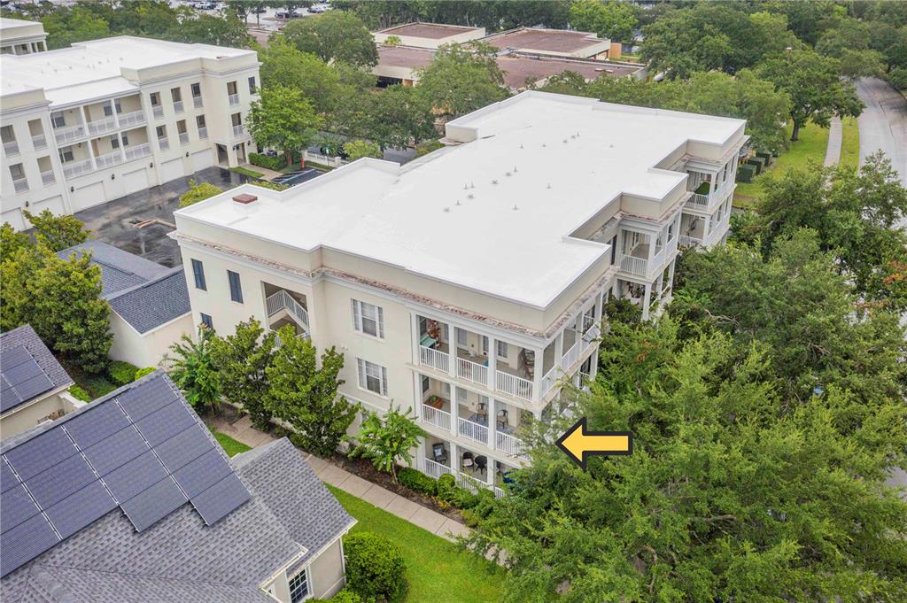 An aerial view of a multi-story apartment building with balconies and a yellow arrow pointing — 2315 UPPER PARK ROAD UNIT 9-203, ORLANDO, FL