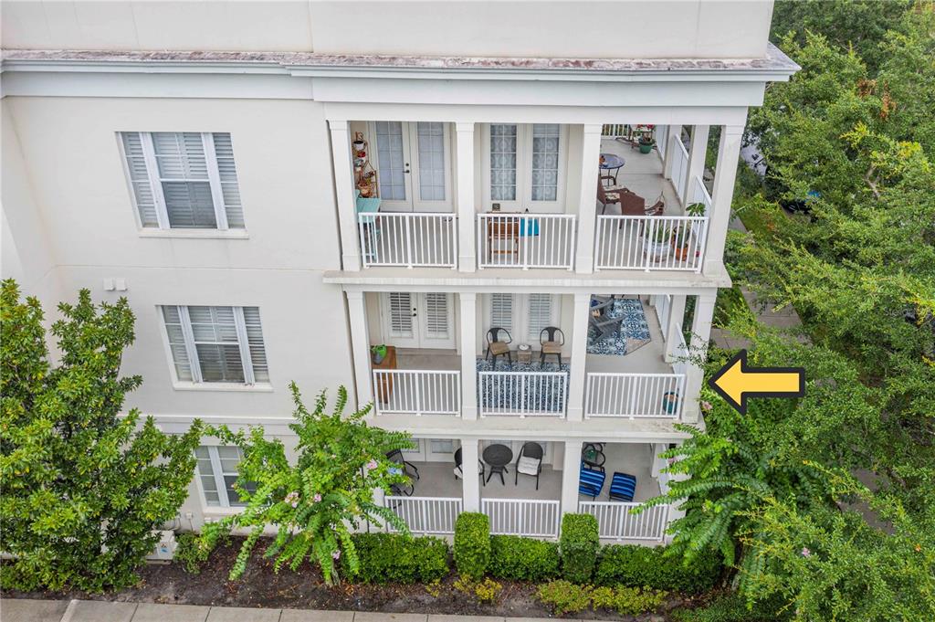 An exterior view of a multi-story building featuring stacked balconies with white railings and furniture — 2315 UPPER PARK ROAD UNIT 9-203, ORLANDO, FL