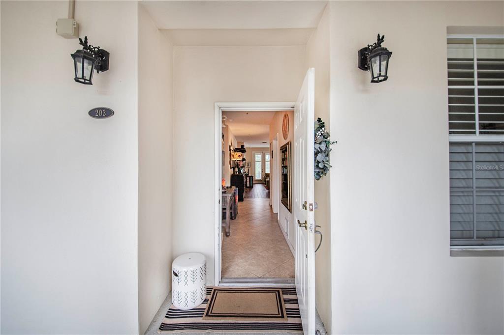 The front entrance features a white door, two wall-mounted lanterns, and a tiled entryway — 2315 UPPER PARK ROAD UNIT 9-203, ORLANDO, FL