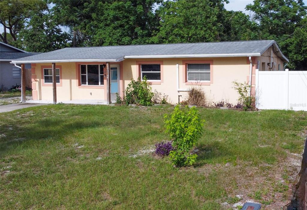 A single-story peach-colored house with a covered front porch and a white vinyl fence — 880 EMERALD DR, MOUNT DORA, FL