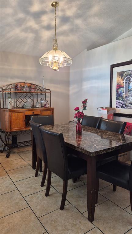 A dining room features a marble-topped table, black chairs, a hutch, and a pendant light — 121 S ROMA WAY, KISSIMMEE, FL