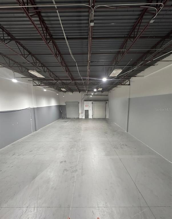 This is an empty industrial warehouse space with a high ceiling and concrete floors — 9777 SATELLITE BOULEVARD, ORLANDO, FL