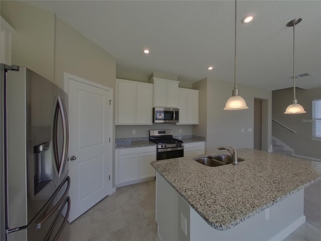 A kitchen with white cabinets, granite countertops, stainless steel appliances, and a central island — 11611 GOLD DUST COURT, RIVERVIEW, FL