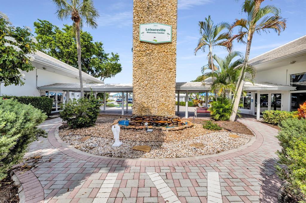 A stone pillar with a welcome sign stands in a courtyard with a small fountain — 2910 E Golf Boulevard, Pompano Beach FL 33064, POMPANO BEACH, FL
