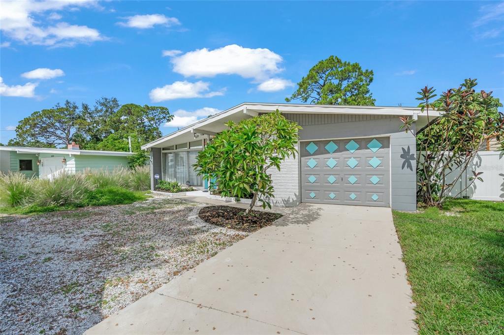 A single-story house with a gray garage door featuring diamond-shaped accents and a concrete driveway — 4801 SARASOTA AVENUE, SARASOTA, FL