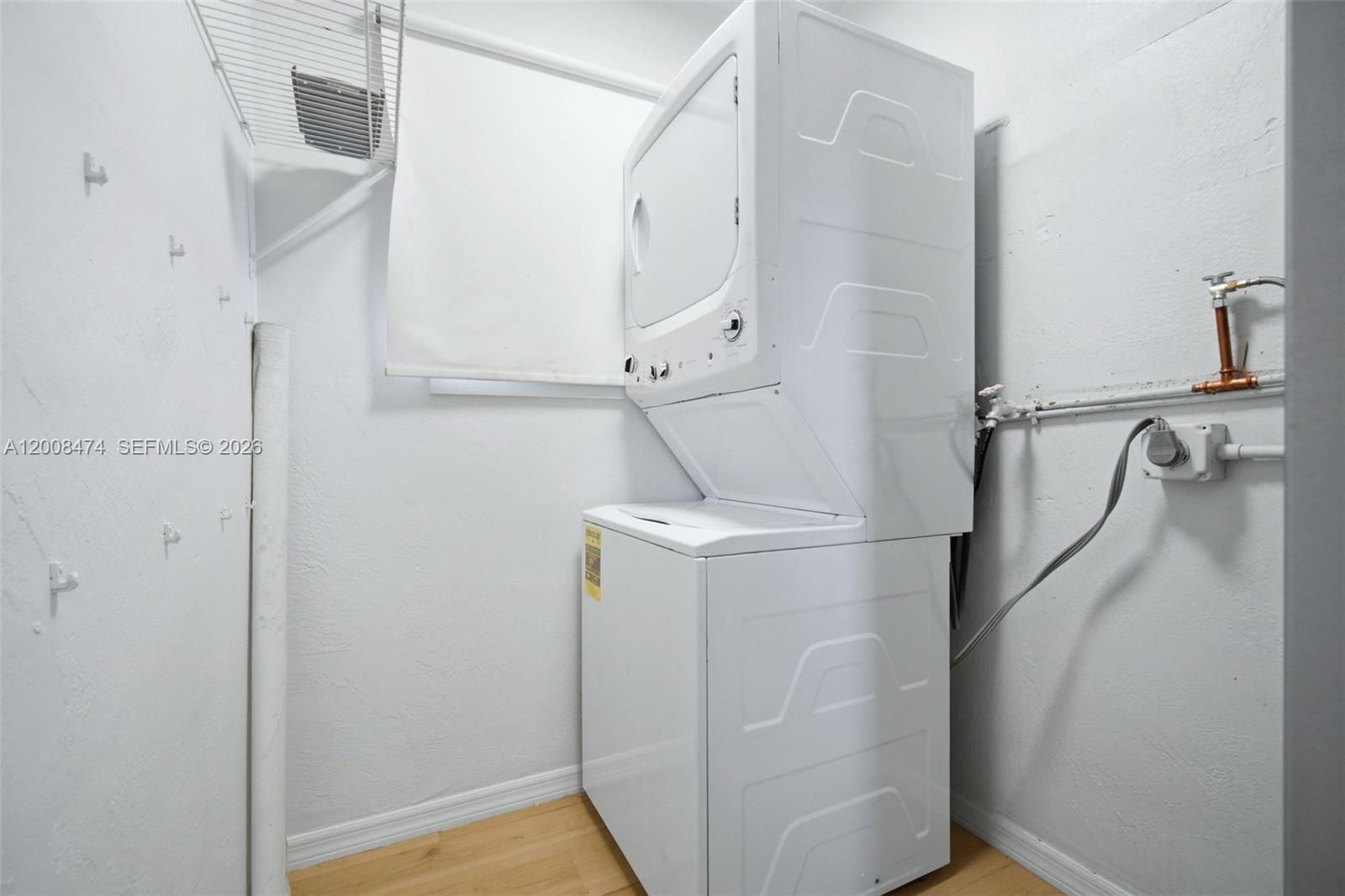 A laundry closet features a stacked washer and dryer unit against a white wall — 2124 Taylor St, Hollywood FL 33020, HOLLYWOOD, FL